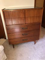Front view of the Mid-Century Modern dresser showing 7 drawers with wood finish and metal handles on lower drawers.