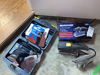 Full view of the open carrying case with sheet sander, sanding sheets, and other accessories alongside the original box.
