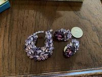 Sherman brooch and matching clip-on earrings shown with a Canadian nickel for scale on wood surface