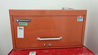 Closed metal Mastercraft toolbox with handle and lock on front.