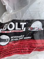 Close-up of Bolt hard hat accessories packaging showing the reversible headlamp mount feature and Bolt branding with a white hard hat illustration.
