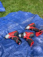 Three impact drivers arranged on blue tarp