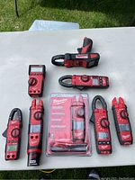 Eight Milwaukee fork meters arranged on a table, four loose and four in packaging.