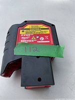 Top view showing caution and model labeling on the laser tool along with a piece of tape marked '112'