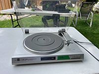 Front angle view of the Dual CS 515 turntable with dust cover open, showing the platter and tonearm.