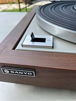 Close-up of wooden base with Sanyo logo and speed switch (33/45 RPM)