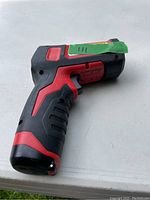 Side angle view of Milwaukee 2266-20 thermometer showing the pistol grip design and red/black color.