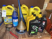 Overview of all fluid containers and funnels on a wooden surface against pegboard background