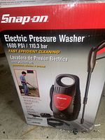 Box and front view of Snap-On electric pressure washer listing main features and specs