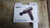 Closed box showing TRAKK Beast Elite Recovery massage gun image and product branding on the front of the packaging.