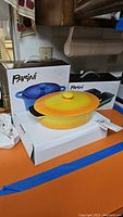 Boxes and items showing Parini brand stoneware covered pans and loaf pans