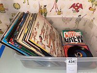 Side view of multiple vinyl record sleeves showing various artists and colorful covers