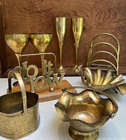 Full view of the nine brass items arranged on a wooden surface