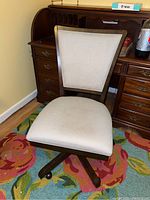 Front view of upholstered adjustable desk chair with beige fabric and wooden frame, showing cushioned seat and trapezoidal backrest.