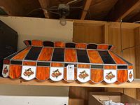Front view showing orange and black striped panels and Orioles logo panels