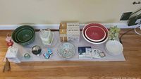 Wide shot of all items arranged showing mixing bowls, plates, containers, salt and pepper shakers, and decorative pieces.