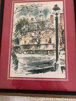 Framed oil painting showing a historical palace in Williamsburg with trees and a street light, signed by artist John Haymson, presented with a red mat.