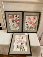 Three framed floral watercolour paintings arranged for display, showing the variety of flowers and general condition of all pieces.