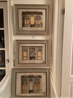 All three framed prints stacked vertically against a wall