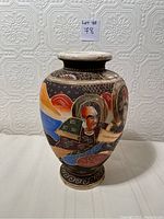 Front view of the Satsuma vase showing a figure with a halo and an architectural element in the background