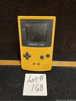 Front view of yellow Nintendo Game Boy Color showing screen and buttons, powered on with Chessmaster game on screen.