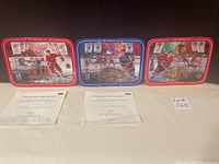 Three hockey collector plates and three certificates of authenticity displayed on a table.