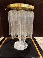 Front view of one Murano Tronchi flush mount light showing textured clear glass tubes mounted on marble base with brass ceiling mount above.