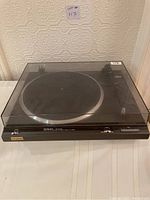 Full view of the Technics SL-Q200 turntable with the dust cover closed, showing overall condition and external details.