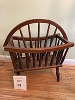 Front and side view of vintage pine wood magazine rack showing arched handle and divided compartments.