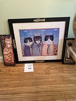Front view of the framed print showing three cats wearing shirts and ties with a black frame featuring fish decorations