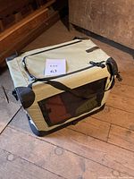 Side view showing front mesh door panel and base of crate, portable and collapsible design with durable fabric and steel tubes.