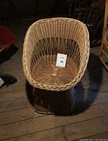 Front view of a rounded egg-shaped rattan wicker chair with woven seat and curved backrest in natural light brown color. Shows good condition for a vintage piece.