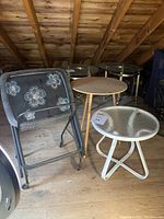 Set shown including three metal TV trays with atomic flower design, one white metal and glass round side table, one wooden round side table base.