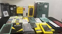 Photo showing wide variety of phone cases and tempered glass screen protectors in packaging and loose.