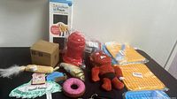 Wide angle photo showing all items in the lot including toys and mats arranged on surface