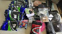 Wide view of assorted fitness accessories including knee pads, ankle weights, gloves, waist belts, and a pink exercise disc