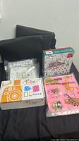 Photo shows boxed items including the camera accessories kit, My Preschool Busy Board, and the puzzle with winter scene.