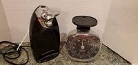 Side view of black electric can opener and mechanical kitchen scale showing condition and accessories.
