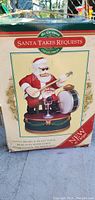 Photo of original product box showing image and description of animated Santa decoration playing instruments, branded Mr. Christmas.
