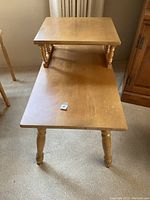 Photo showing rectangular coffee table with two tiers, turned legs and maple finish.