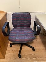 Front view of plaid office chair with checkered fabric, black armrests, and wheel base.