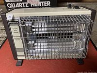 Front angle photo of Heatstar Quartz Fan Heater model QH-1600 with metal protective grill and control knobs, beige color.