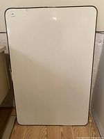 Photo showing front surface of the white board with rounded corners and a thin border.