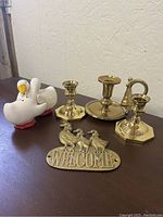 Photo showing all brass candle holders, brass welcome sign with geese, and ceramic goose/duck salt and pepper shakers