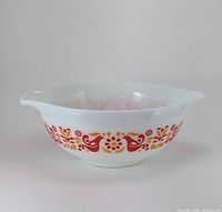 Side view of Pyrex Friendship 443 mixing bowl showing red and orange bird and floral graphic pattern