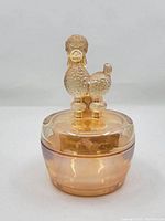 Front view of the amber Jeanette glass powder jar with the poodle figurine lid attached.