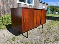 Side angled view showing the walnut wood finish, brass handle, and tapered leg design of the mid century credenza.