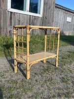 Full view of the rectangular rattan bamboo table outdoors in sunlight showing the frame and lattice sides.