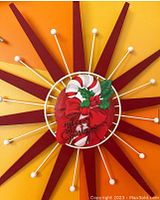 Starburst wall hanger featuring red wooden rays and white spherical-tipped rods, central Christmas 'Merry Christmas' sign with candy canes and holly.
