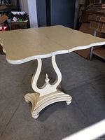 Fold-top table showing the scalloped edges and split center seam where the top folds open.